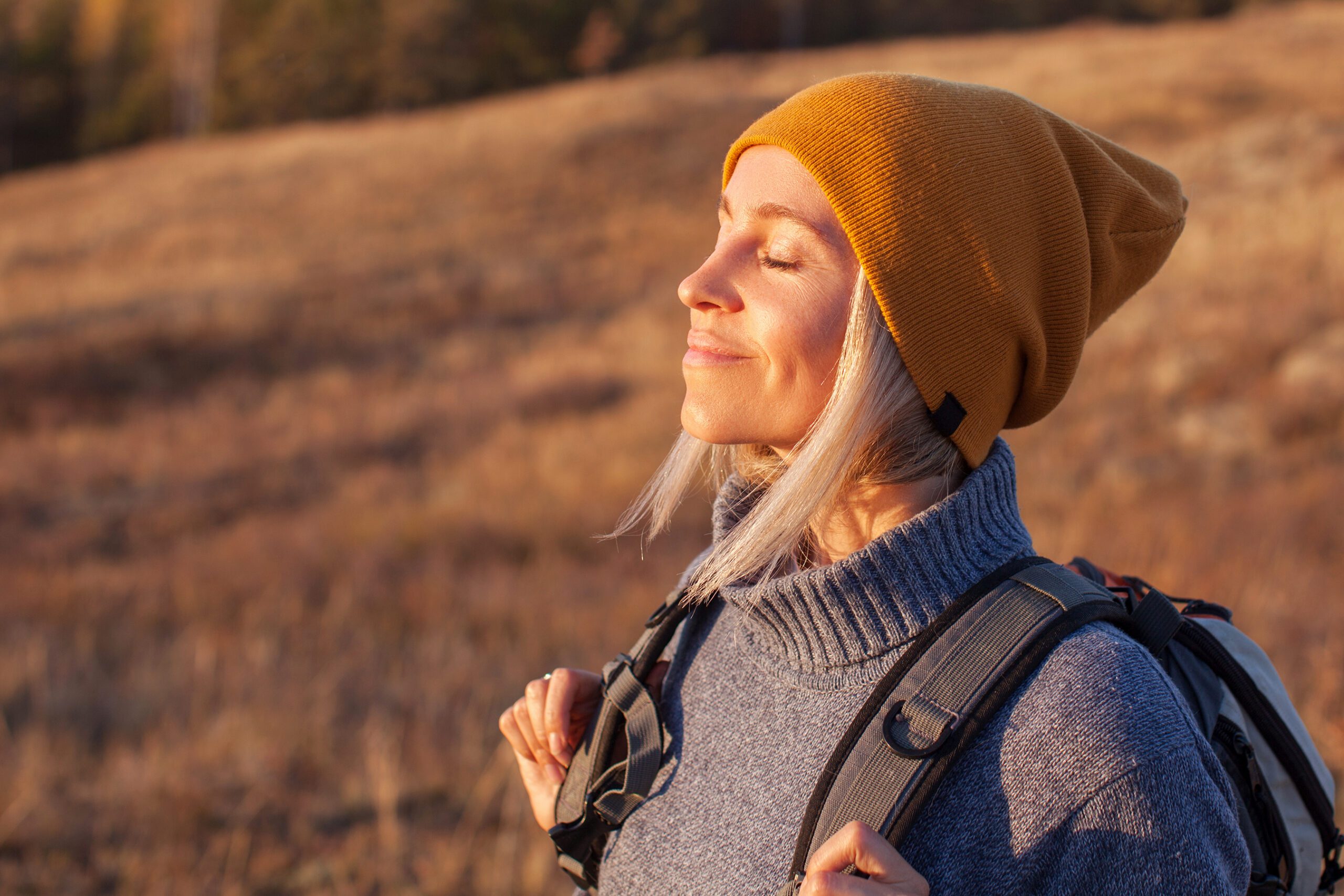 Middle age woman breathing fresh air in a forest in autumn.